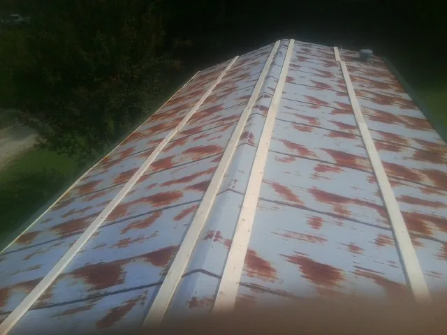 Rusted metal roof panels with new wood purlins before replacement — Storm Damage Roof Repair in Westhampton by Roofing Brothers