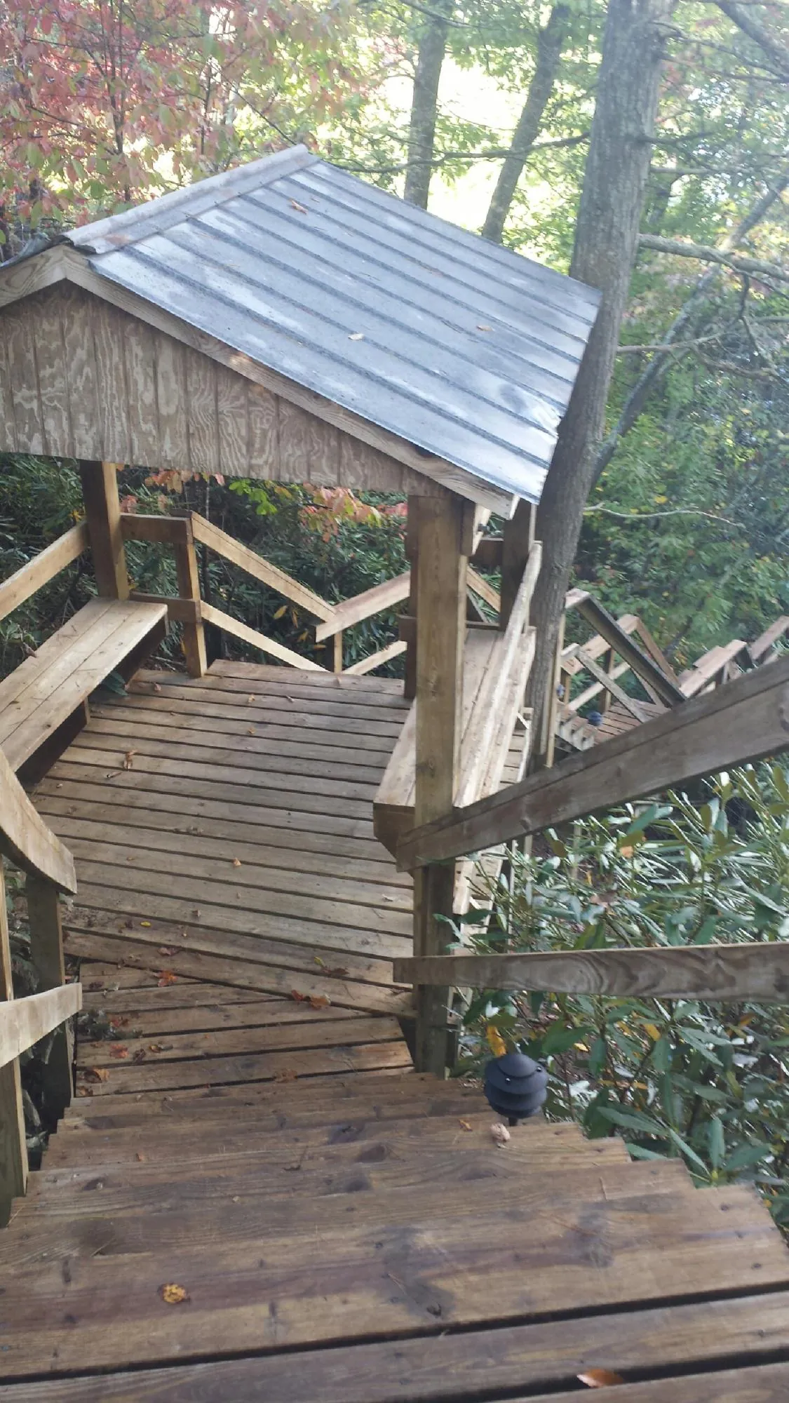 Metal roofed shelter over wooden steps on a wooded walkway — Skylight Repair & Installation work by our crew in Westhampton